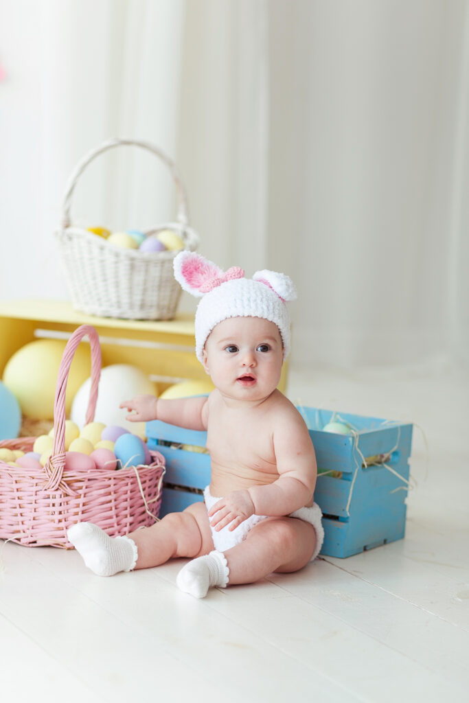 cute little girl with easter eggs sitting on floor at home